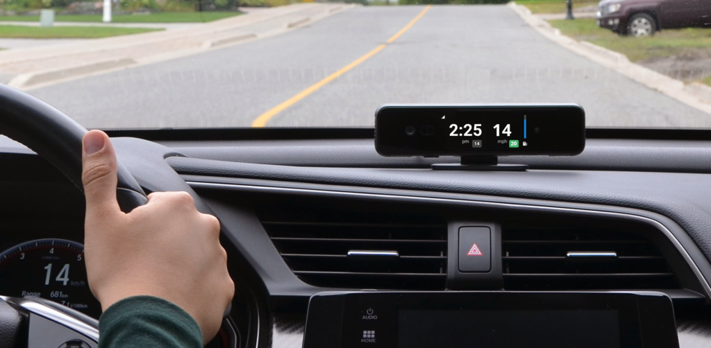 A car dashboard with a Zubie dashcam installed.