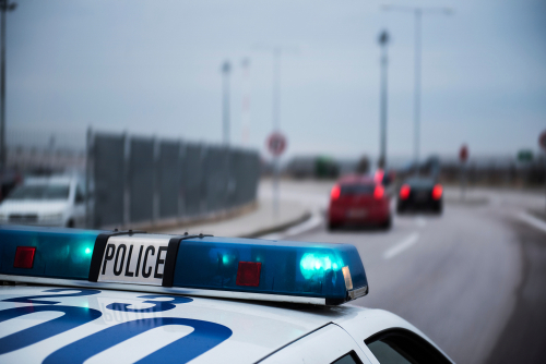 A flashing police car pursues vehicle thieves.