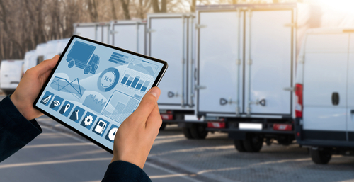 A fleet manager uses a tablet to track a fleet of trucks.