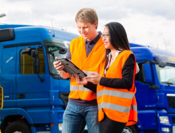 A fleet driver reviews their performance on driver tracking software with their supervisor.