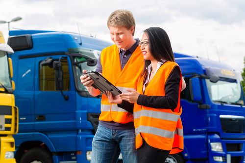 A fleet driver reviews their performance on driver tracking software with their supervisor.