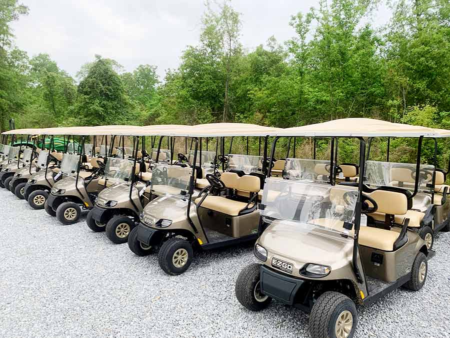 rows of golf carts on a gravel surface