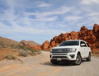 white ford expedition facing camera on a desert road