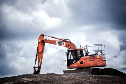 orange construction digger on dirt hill