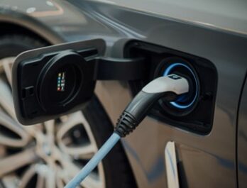 close up of electric vehicle charging port with charger inserted