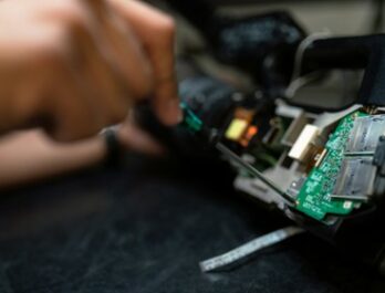 close up of hand using a screwdriver on an electronics panel